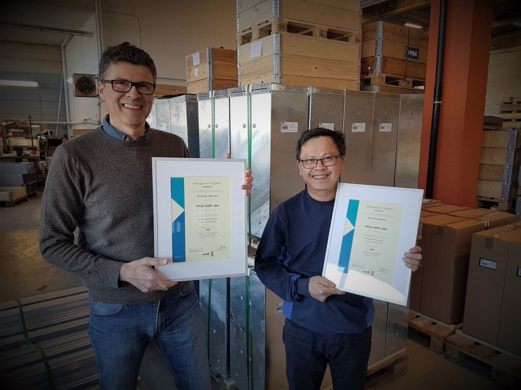 bildet viser to blide menn med hvert sitt sertifikat